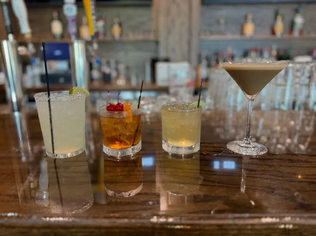 Four cocktails on the bar: a margarita, a Manhattan, a mule and an espresso martini
